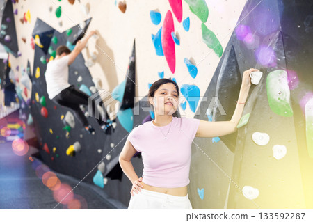 Sports positive woman climber on background of climbing wall 133592287