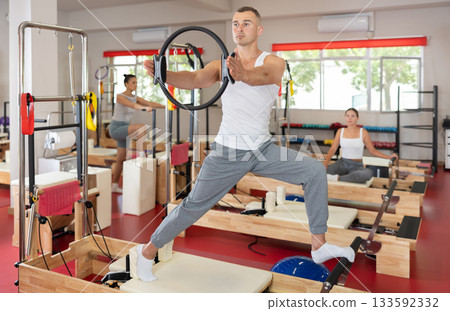 Young man doing exercises with pilates ring 133592332