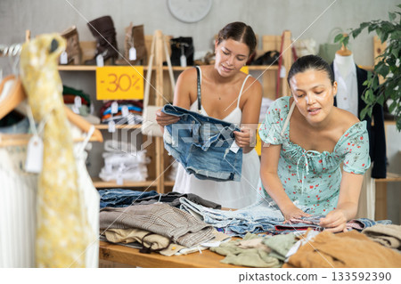 Women customers turn over and choose trousers or shorts in store Women customers turn over and choose trousers or shorts in store 133592390