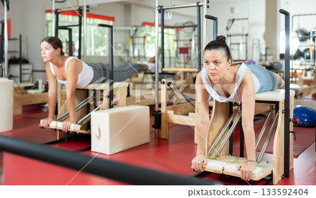 Active young girl doing press exercises on combo chair 133592404