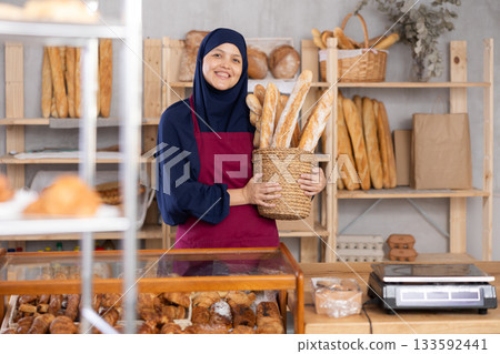 Muslim seller holding bread in shop 133592441