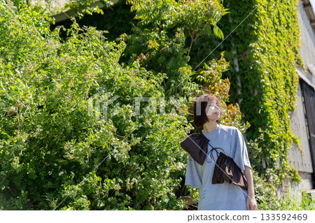 一位女士站在綠色柵欄前。 一位女士站在綠色柵欄前。 133592469