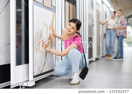 Young woman chooses tiles in hardware store 133592477