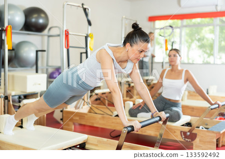 Young woman training her abs on pilates reformer 133592492