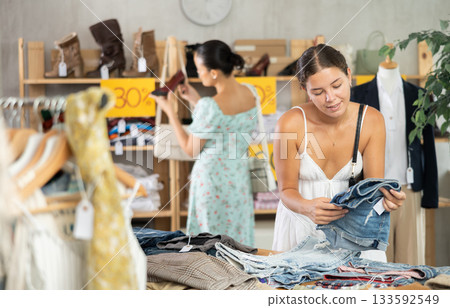 Young woman choosing jean shorts in clothing store 133592549
