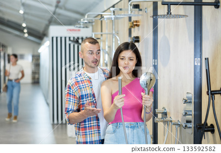 Married couple chooses a shower head in hardware store Married couple chooses a shower head in hardware store 133592582