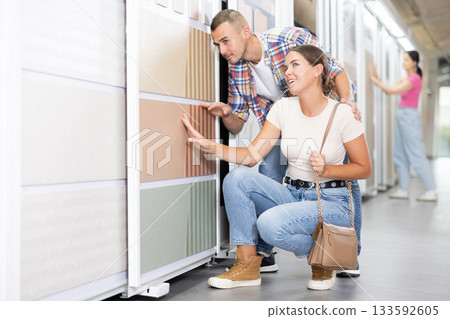 Couple of man and woman choose tiles in store Couple of man and woman choose tiles in store 133592605