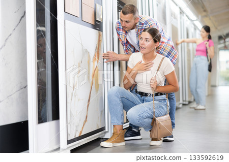Couple of man and woman choose tiles in store 133592619