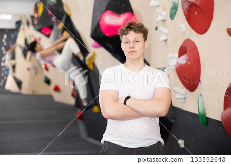 Teen guy posing against climbing wall 133592648