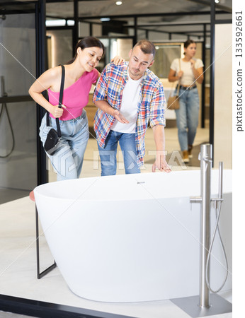 Married couple discussing bathtub colors in hardware store 133592661