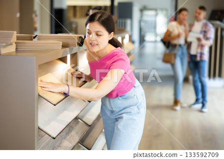 Young woman buying laminate flooring at hardware store 133592709