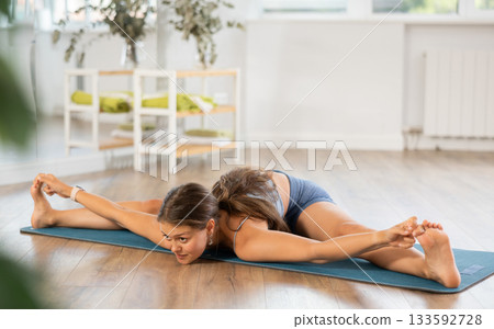 Lover of active lifestyle on yoga mat perform doing Supt Kurmasa in gym Lover of active lifestyle on yoga mat perform doing Supt Kurmasa in gym 133592728
