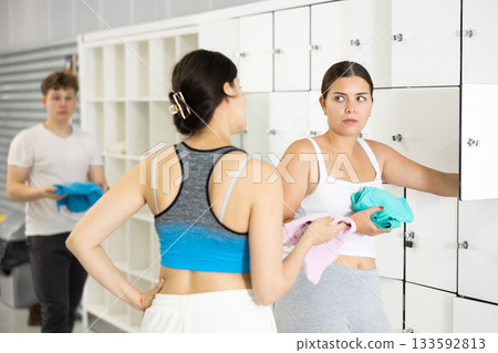 Two young women talking near lockers in locker room Two young women talking near lockers in locker room 133592813