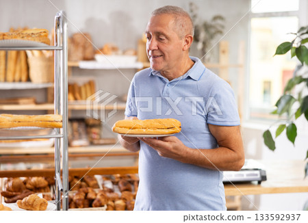Elderly man with bocadillo sandwich in bakery Elderly man with bocadillo sandwich in bakery 133592937