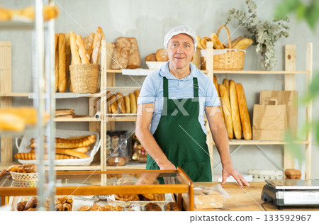 Elderly man seller posing in bakery 133592967