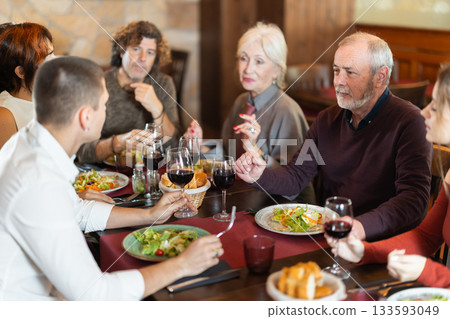 Family members enjoying warm conversation in restaurant 133593049