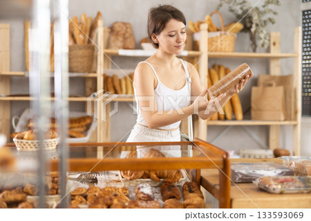 Girl in casual clothes chooses fresh cookie for breakfast in bakery Girl in casual clothes chooses fresh cookie for breakfast in bakery 133593069