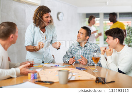 Cheerful man playing board game with male friends 133593115