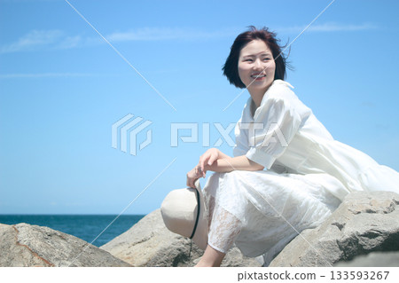 A woman sitting on the beach 133593267