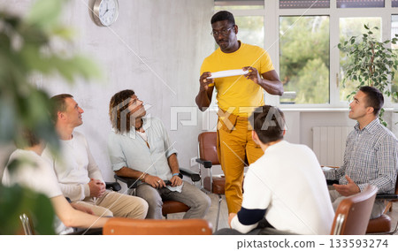 Middle-aged teacher speaking to a group of guys 133593274