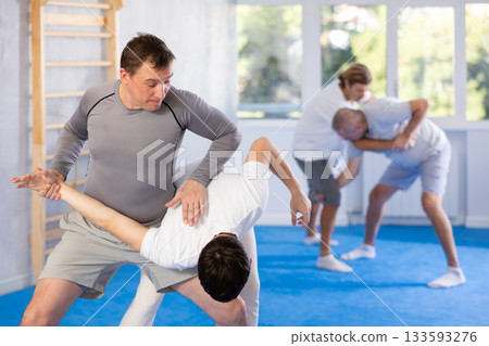 Two men training judo technique in studio Two men training judo technique in studio 133593276