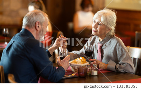 Happy senior couple enjoying dinner together in restaurant Happy senior couple enjoying dinner together in restaurant 133593353