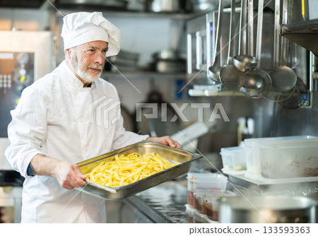 Senior man cooker work at kitchen Senior man cooker work at kitchen 133593363