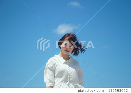 A young lady looking up at the blue sky A young lady looking up at the blue sky 133593622