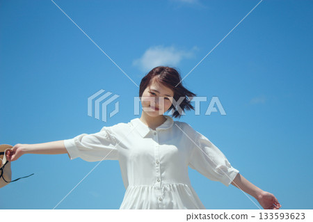 A woman spreading her hand under the blue sky 133593623