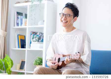 Man playing the ukulele Man playing the ukulele 133593726
