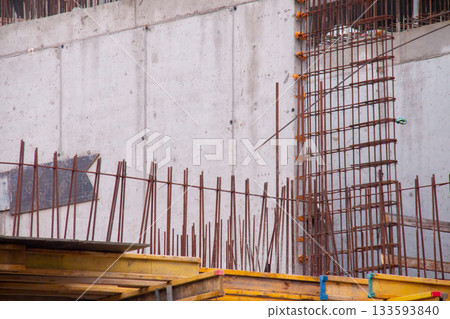 Concrete Wall Frame Building under Construction with Yellow Volumetric I-Beams. Monolithic Box with Formwork Prints and Rebar releases on Construction Site. Architectural origin Structure. 133593840