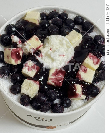 Blueberry bingsu served in a bowl with finely shaved ice, topped with fresh blueberries, syrup, and creamy toppings, showcasing vibrant colors and refreshing texture in close-up detail Blueberry bingsu served in a bowl with finely shaved ice, topped with fresh blueberries, syrup, and creamy toppings, showcasing vibrant colors and refreshing texture in close-up detail 133594127
