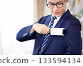 A middle-aged man removes dirt from his suit with a sticky cleaner in the morning 133594134