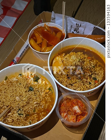 Steaming hot ramyun with rich, savory broth and chewy noodles, paired with spicy, tangy kimchi. A perfect Korean comfort food combination, balancing bold flavors and satisfying textures. 133594163
