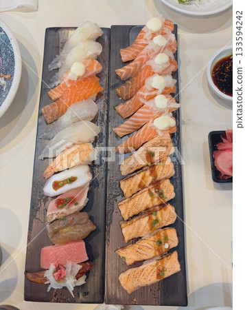 An assortment of fresh sushi, artfully arranged with a variety of toppings and vibrant colors. This traditional Japanese dish combines vinegared rice, seafood, and vegetables for an experience. An assortment of fresh sushi, artfully arranged with a variety of toppings and vibrant colors. This traditional Japanese dish combines vinegared rice, seafood, and vegetables for an experience. 133594242