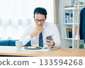 A man eating while looking at his smartphone before going to work 133594268
