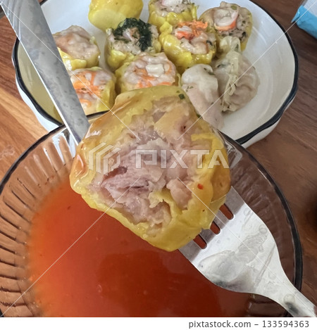 Shumai shrimp with sauce, Steamed shrimp dumplings dim or dim sum and vegetable on wooden table, Cantonese Dimsum food cuisine for breakfast, Chinese traditional food. Shumai shrimp with sauce, Steamed shrimp dumplings dim or dim sum and vegetable on wooden table, Cantonese Dimsum food cuisine for breakfast, Chinese traditional food. 133594363