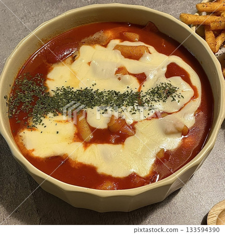 Spicy Korean tteokbokki with chewy rice cakes in a vibrant red sauce, topped with sesame seeds and green onions. A popular street food known for its addictive flavor and satisfying texture. Spicy Korean tteokbokki with chewy rice cakes in a vibrant red sauce, topped with sesame seeds and green onions. A popular street food known for its addictive flavor and satisfying texture. 133594390