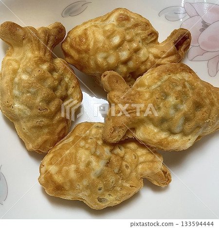 Crispy and golden mini bungeoppang with a soft, fluffy filling of sweet red bean or custard. A delightful bite-sized Korean fish-shaped pastry, perfect for a warm and nostalgic treat! 133594444