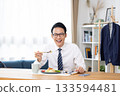 A man eating while looking at his smartphone before going to work 133594481