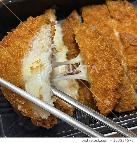 Crispy tonkatsu cutlet stuffed with melted cheese, creating a savory blend of crunch and creaminess. A comforting and satisfying dish with a rich, golden finish. Crispy tonkatsu cutlet stuffed with melted cheese, creating a savory blend of crunch and creaminess. A comforting and satisfying dish with a rich, golden finish. 133594575