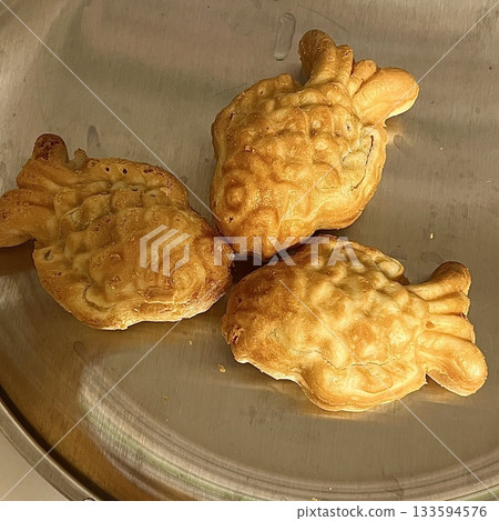 Crispy and golden mini bungeoppang with a soft, fluffy filling of sweet red bean or custard. A delightful bite-sized Korean fish-shaped pastry, perfect for a warm and nostalgic treat! 133594576