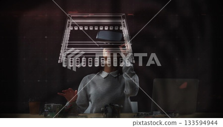 Gesturing female engineer manipulating holographic circuit schematic at lab desk, with AR headset Gesturing female engineer manipulating holographic circuit schematic at lab desk, with AR headset 133594944