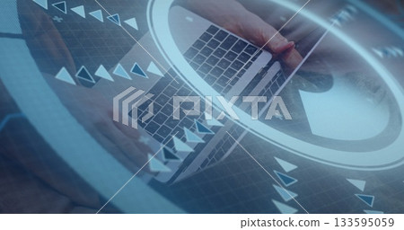 Woman's hands holding smartphone and tapping laptop keyboard at wooden work desk, with data overlay 133595059