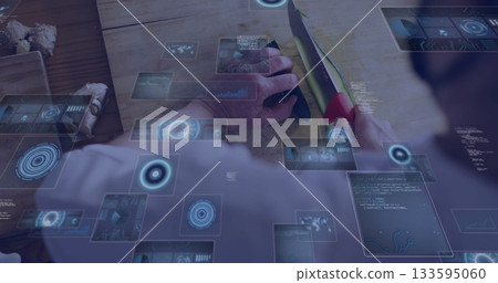 Slicing woman cutting green vegetable using red-handled knife on kitchen bench, with blue holograms Slicing woman cutting green vegetable using red-handled knife on kitchen bench, with blue holograms 133595060