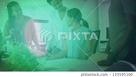 Collaborating business women sketching on layout drawings in office, with blueprints pen folders 133595100