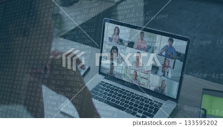 Showing laptop displaying nine-person team meeting in office with smartphone and code overlay 133595202