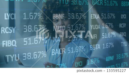 Holding notebook and pen, woman in blue blouse analyzing data on office glass wall, with laptop 133595227