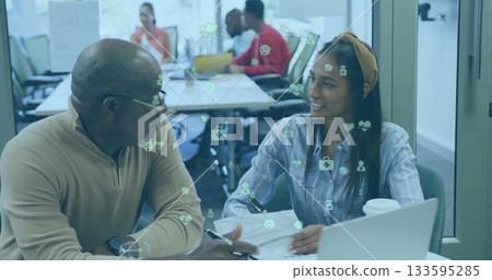 Collaborating man wearing glasses and woman writing on laptop at table, with digital health icons Collaborating man wearing glasses and woman writing on laptop at table, with digital health icons 133595285