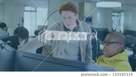 Leaning software engineer showing code to colleague at tech office, with digital likes overlay 133595314